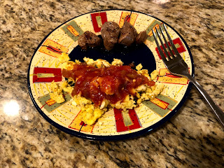 venison cutlets on a plate with eggs covered in salsa