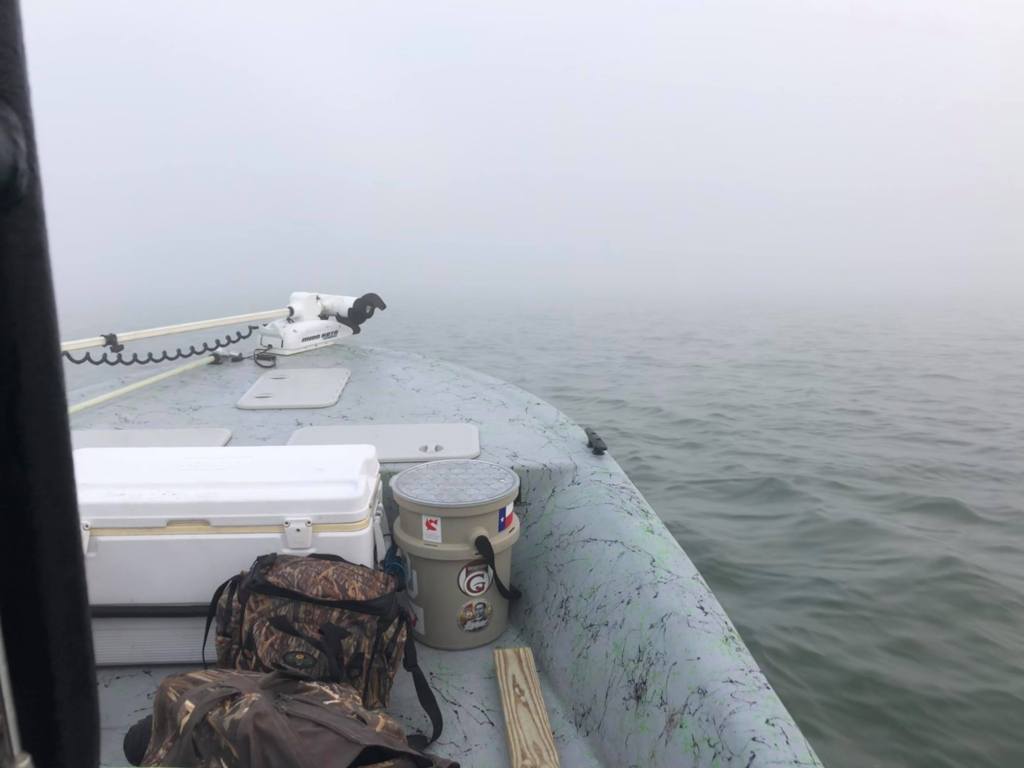 The front of a boat and fog pressing in close