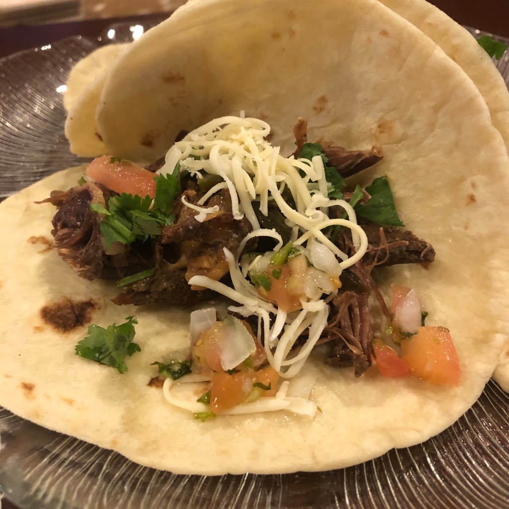 Wild turkey tacos with cilantro, shredded cheese, on a tortilla