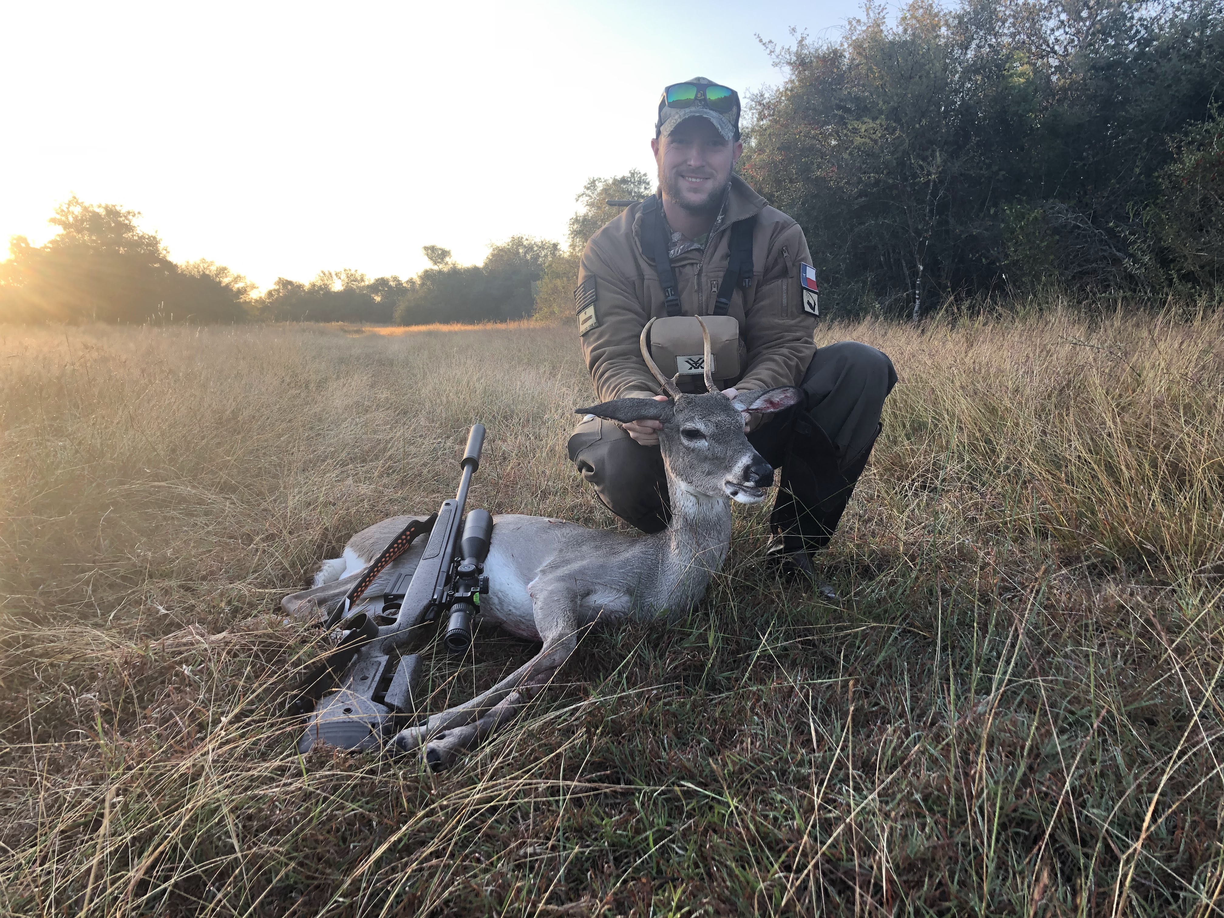 Court with a whitetail spike and his rifle