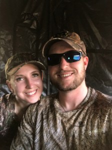 Court and Jessica smiling for a picture in the deer blind
