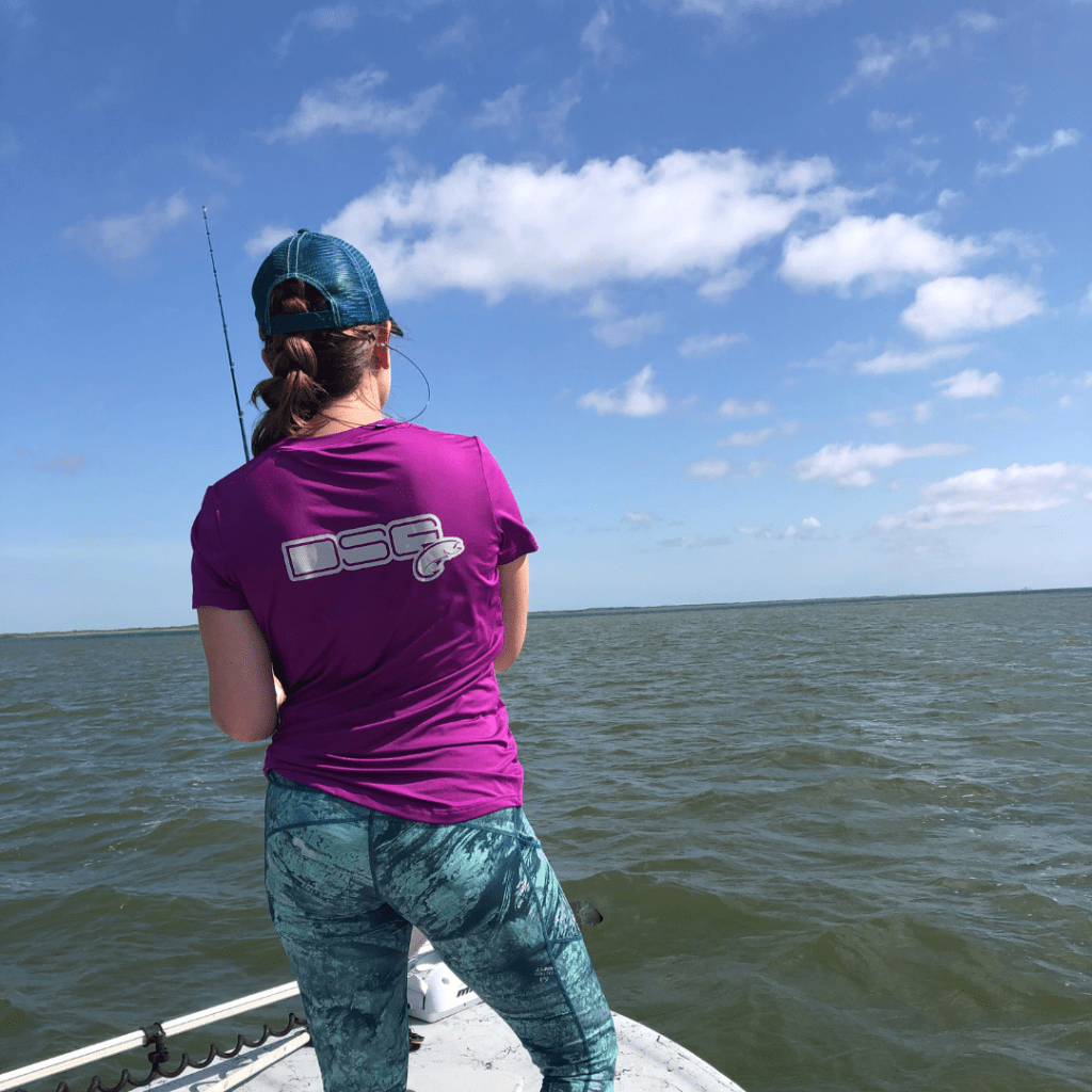 girl standing on a boat in fishing gear