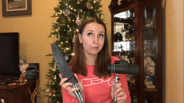 jessica in front of a christmas tree holding up a fishing knife and monocular