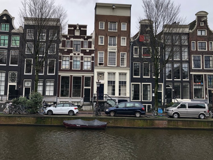 Amsterdam buildings clustered close together behind a canal