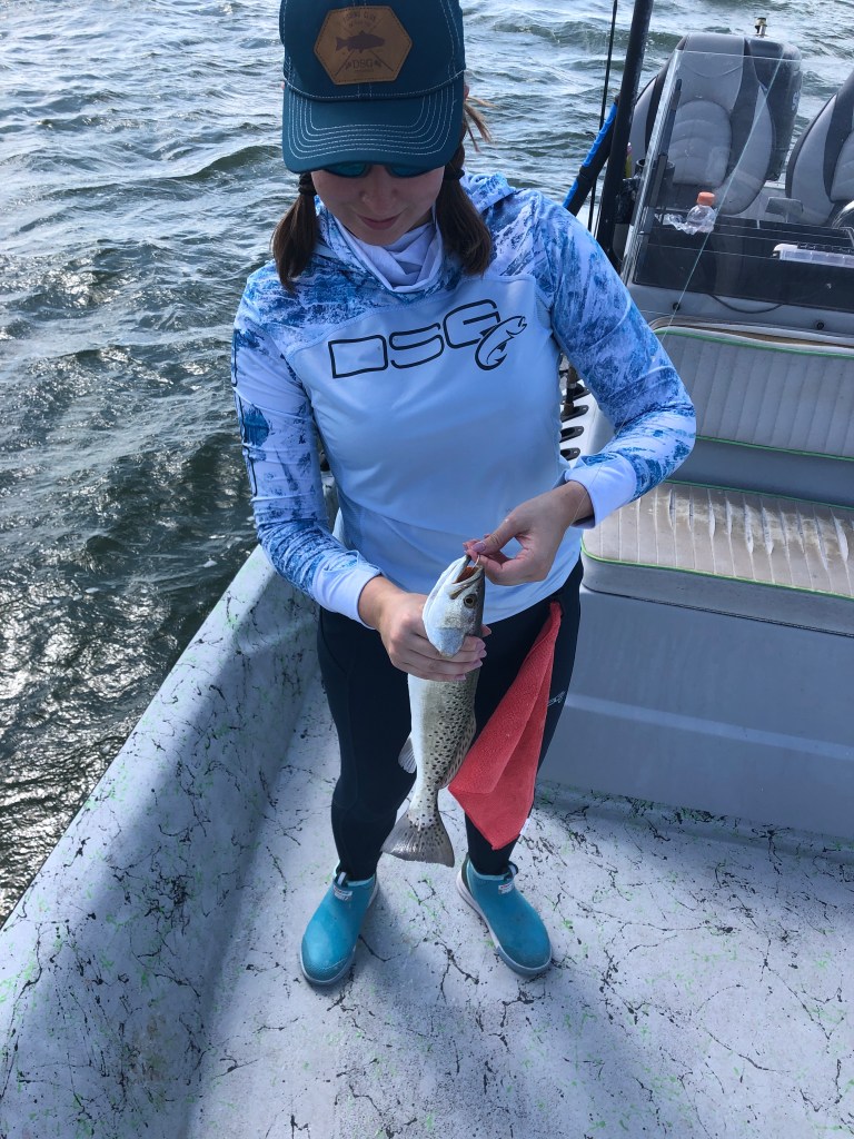jessica taking the hook out of a small speckled trout