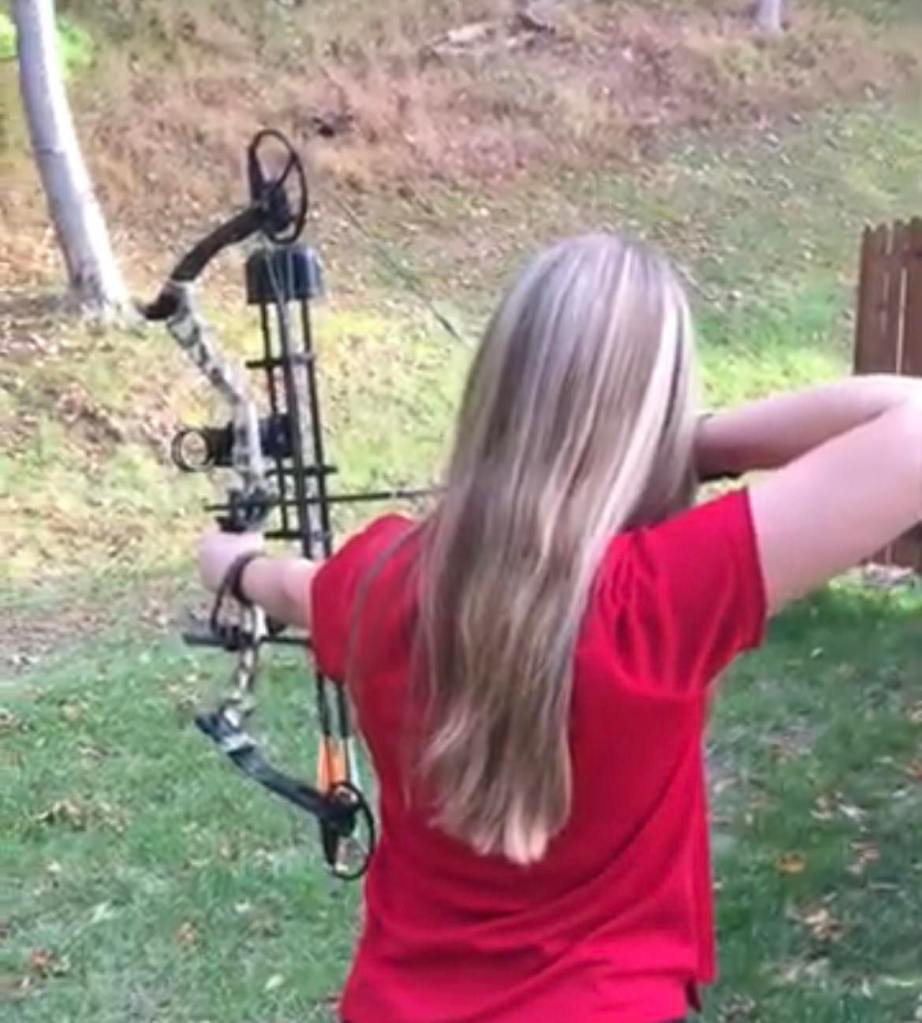jessica holding up her compound bow with her back to the camera